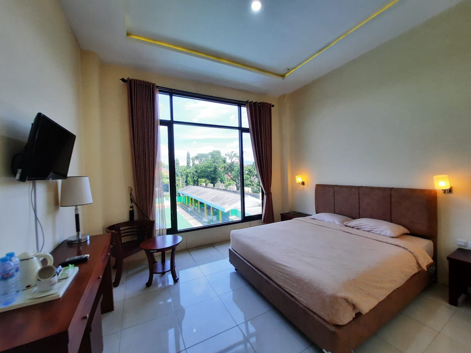 Kamar Deluxe dengan tempat tidur besar dan pemandangan taman